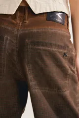 Jean slouchy marrón de tiro alto con silueta barrel relajada que se estrecha hacia los tobillos y textura de cuadros sutil.