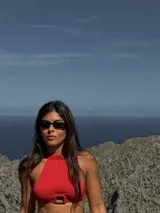 Top de bikini rojo con textura, corte halter y argolla decorativa.