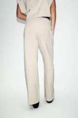 Pantalón de tiro medio confeccionado en tejido de punto elástico con pierna recta. Cuenta con cintura elástica ajustable mediante cordones y bolsillos laterales.