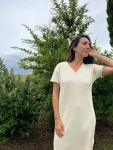 Vestido remerón largo color crudo, con escote en V y mangas cortas. Confeccionado en morley de algodón orgánico y bambú.