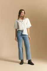 Jean de corte recto y tiro medio, confeccionado en denim elastizado de color negro. Presenta un diseño clásico con cierre de botón y cremallera, bolsillos laterales y traseros, y ruedo con terminación deshilachada.