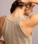 Blusa sin mangas color beige, confeccionada en tejido de punto acanalado con hilo metalizado, escote alto y corte ajustado.
