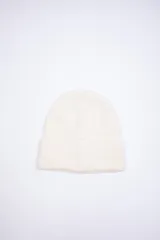 Gorro de lana color crudo, tejido de punto con doblez.