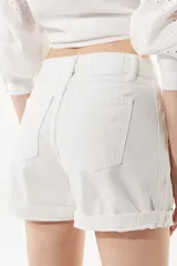 Short de jean blanco, corte mom, con estrellas bordadas a tono en el lateral y ruedo doblado.
