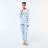 Pijama de dos piezas compuesto por una remera de manga larga y un pantalón largo, ambos en color celeste con estampado integral del personaje Stitch y pequeños corazones negros. La remera presenta el nombre del personaje en el frente.