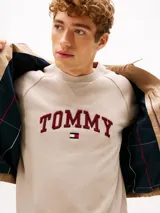 Campera Tommy Hilfiger modelo Ivy, color beige, confeccionada en tejido técnico impermeable y resistente al viento. Cuenta con cuello clásico, cierre frontal de cremallera, bolsillos laterales ribeteados y parche engomado en la manga.