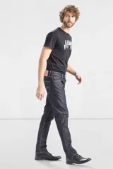 Jean de corte slim fit, color azul oscuro con costuras en contraste. Presenta diseño de cinco bolsillos, cierre frontal con cremallera y botón metálico.