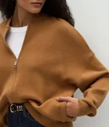Campera de punto de corte regular y estilo oversized, confeccionada en una mezcla de viscosa, poliéster y poliamida. Presenta cierre frontal completo, mangas largas con puños acanalados y acabado acanalado en el ruedo.