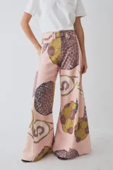 Pantalon de corte wide leg con tiro alto, confeccionado en tela de algodón con estampado gráfico de motivos deportivos en tonos rosado, ocre y marrón. Presenta cierre frontal con botón y bolsillos laterales.