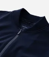 Campera tipo bomber color beige, con cierre frontal de cremallera, cuello estilo béisbol, puños y ruedo acanalados. Cuenta con bolsillos laterales con cierre y tecnología repelente al agua.