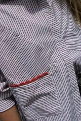 Camisa oversize a rayas verticales azules y blancas, con bolsillo en el pecho con detalle bordado.