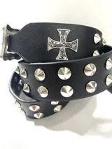 Cinto de cuero negro con tachas cónicas metálicas y hebilla plateada con diseño grabado de rosas y cruz.