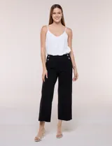Pantalón crop negro de corte recto y tiro alto, con cintura ancha y detalle de botones decorativos en los laterales. Presenta costuras verticales frontales que estilizan la silueta.