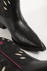Botas de cuero negras con diseño de estilo western, con puntera fina y detalles de estrellas en color borgoña y blanco.