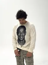 Remera de manga larga color beige con estampado fotográfico frontal de Ronaldinho en blanco y negro. Presenta un corte oversize y cuello redondo.