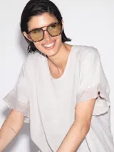 Blusa blanca de lino con cuello redondo y mangas cortas con terminación desflecada.