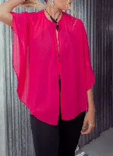 Capa corta color fucsia de gasa, estilo torerita, con mangas amplias y abertura frontal.