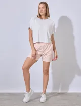 Short de algodón color rosa claro, con pretina ancha elastizada y bolsillos inclinados en la parte delantera.