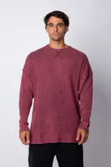 Buzo de corte oversize confeccionado en tela waffle de algodón con proceso de teñido acid wash. Presenta cuello redondo con detalle de costura en X y mangas largas con puños acanalados.