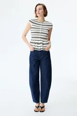 Saco ajustado en punto fino suave, de color blanco con rayas negras, cuello redondo, manga japonesa, botones hasta la cintura y peplum acampanado.