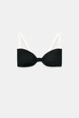 Top de bikini negro con escote corazón, nudo en el centro del pecho y tirantes dobles trenzados de color blanco marfil.