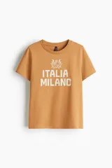 Remera de punto de algodón color tostado, con cuello redondo y diseño estampado en el frente con la inscripción 'Italia Milano' y un escudo decorativo.