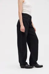 Jean de tiro alto con silueta tipo globo, de cintura ajustada y piernas holgadas que se estrechan hacia el bajo.