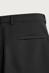 Pantalón regular fit de hombre color negro, confeccionado en tejido técnico ligero con cintura elástica, bolsillos frontales, bolsillos traseros de vivo y cierre frontal con cremallera y botón.
