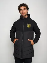 Parka negra con capucha, cierre frontal con cremallera, bolsillos laterales con cremallera y escudo del Club Atlético Peñarol en el pecho.
