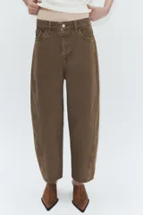 Jeans de tiro medio con corte cropped y diseño de costuras torcidas. Presenta trabillas en la cintura, cinco bolsillos clásicos y cierre frontal con cremallera y botón metálico.