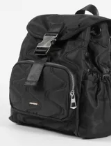 Mochila color beige con diseño acolchado en forma de ondas. Tiene un bolsillo frontal con cierre, correas ajustables y cierre con hebilla.