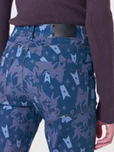 Pantalón de jean de tiro medio con corte de pierna recta y ajuste cómodo. Presenta un estampado integral con motivos geométricos y abstractos en tonos azules.