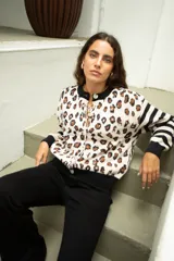 Saco de punto con diseño combinado de estampado animal print en el cuerpo y rayas horizontales en las mangas. Presenta cuello redondo, cierre frontal con botones y terminaciones en tejido acanalado negro.