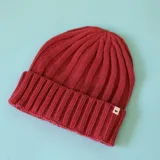 Gorro tipo beanie de tejido de punto acanalado en color bordó, con vuelta en el borde y etiqueta pequeña con logo N+.