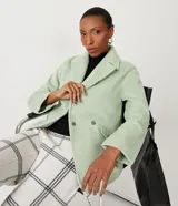 Saco cruzado de mujer color verde menta, con cuello solapa y manga larga. Presenta bolsillos frontales con solapa y cierre de botón.