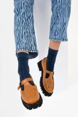 Mocasines de cuero color borgoña con detalle de tejido trenzado en la parte delantera, hebilla metálica y suela track color caramelo.