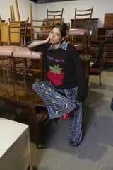 Sweater tejido de lana merino color negro, con cuello a la base y puños. Presenta un bordado artesanal de una frutilla en el frente.