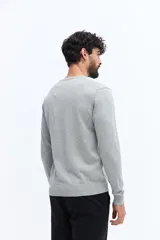 Sweater de hombre con escote redondo, manga larga y calce regular. Presenta un pequeño logo bordado en el pecho y puños acanalados.