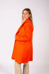 Tapado de paño color naranja, con solapas clásicas, cierre frontal y bolsillos laterales con solapa.