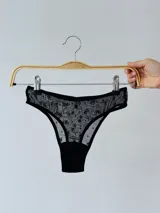 Pantie tipo tanga de microtul negro con estampado de pequeñas flores.