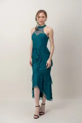 Vestido midi verde oscuro de tul bordado, con escote halter y diseño asimétrico con volados en la falda.