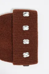 Gorro tipo beanie de punto acanalado color marrón, con vuelta y aplicación de cuatro cristales rectangulares transparentes en la parte frontal.