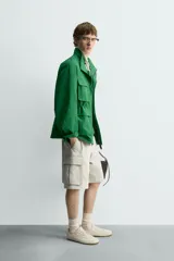 Bermuda cargo de algodón color beige claro, con corte relajado, bolsillos laterales de parche con solapa y bolsillos traseros de vivo.