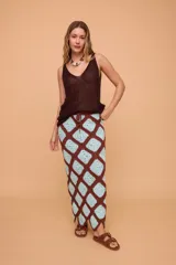 Pollera midi tejida a crochet con diseño de rombos en color marrón y celeste. Tiene elástico en la cintura y llega hasta los tobillos.