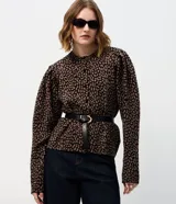 Cardigan de punto con estampado animal print, cuello redondo y cierre frontal con botones. Presenta mangas largas abullonadas con puños ajustados y un corte corto.