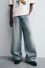 Jeans de denim de algodón, color azul oscuro con efecto lavado. Presentan un corte muy holgado (baggy fit) en toda la pierna y tiro medio. Tienen cinco bolsillos y cierre frontal con cremallera y botón.