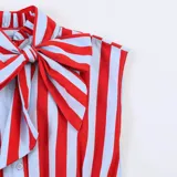 Blusa sin mangas con estampado de rayas verticales rojas y blancas, cuello alto con lazo grande y detalle de volados en la cintura.
