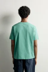 Camiseta regular fit de color verde, con cuello redondo, manga corta y un bolsillo de parche en el pecho con detalle de etiqueta estampada.