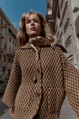 Chaqueta de punto con estructura, corte oversize, cuello solapa, manga larga, bolsillos delanteros y cierre frontal con botones.