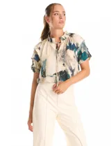 Blusa de gasa con estampado abstracto en tonos verdes, azules y beige. Presenta cuello mao fruncido con escote en V regulable mediante lazos, y mangas cortas con volados y puños elásticos.